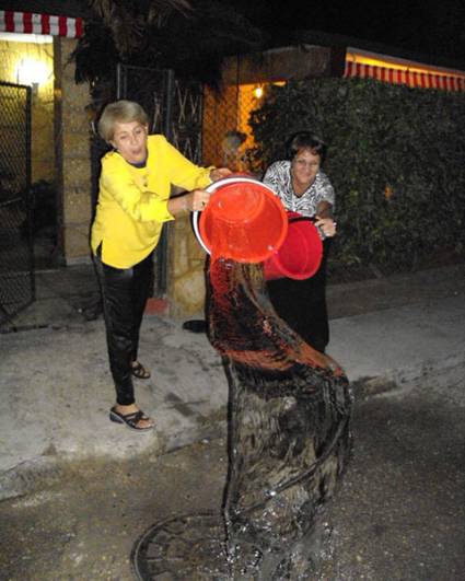 A las 12:00 a.m., con cubos de agua, se tira lo malo del año viejo. Foto: Juventud Rebelde.